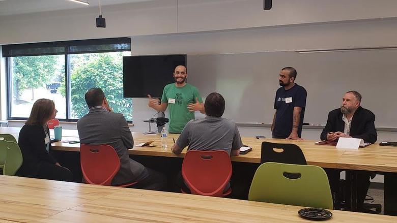 People sitting and standing around a table while talking